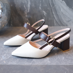White shoes with brown straps on a gray surface