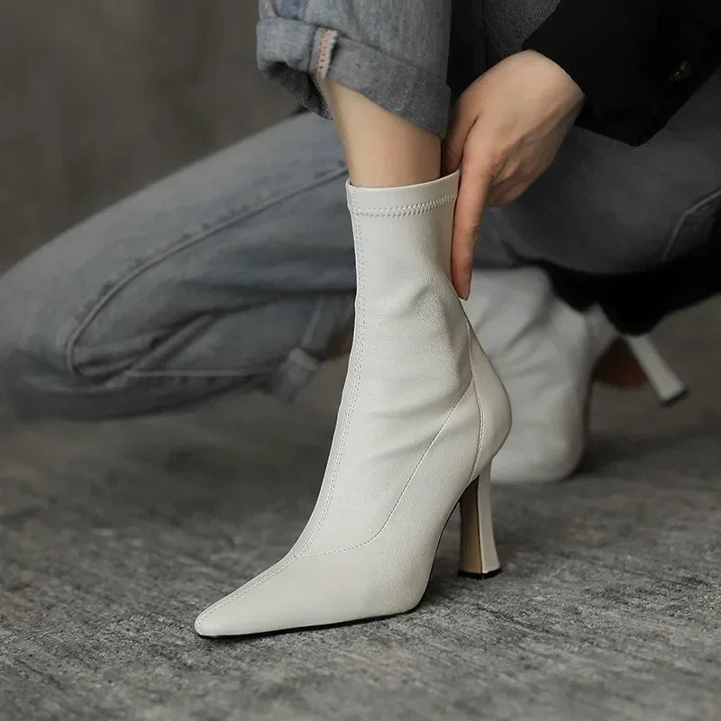 White sock boot being worn on a gray surface