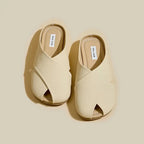 Pair of beige open-toe sandals on a beige background