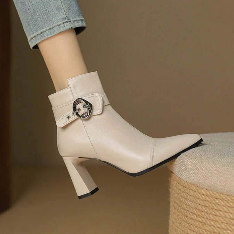 Beige ankle boot with a buckle on a brown background