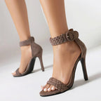 Brown high-heeled sandals with braided straps on a neutral background