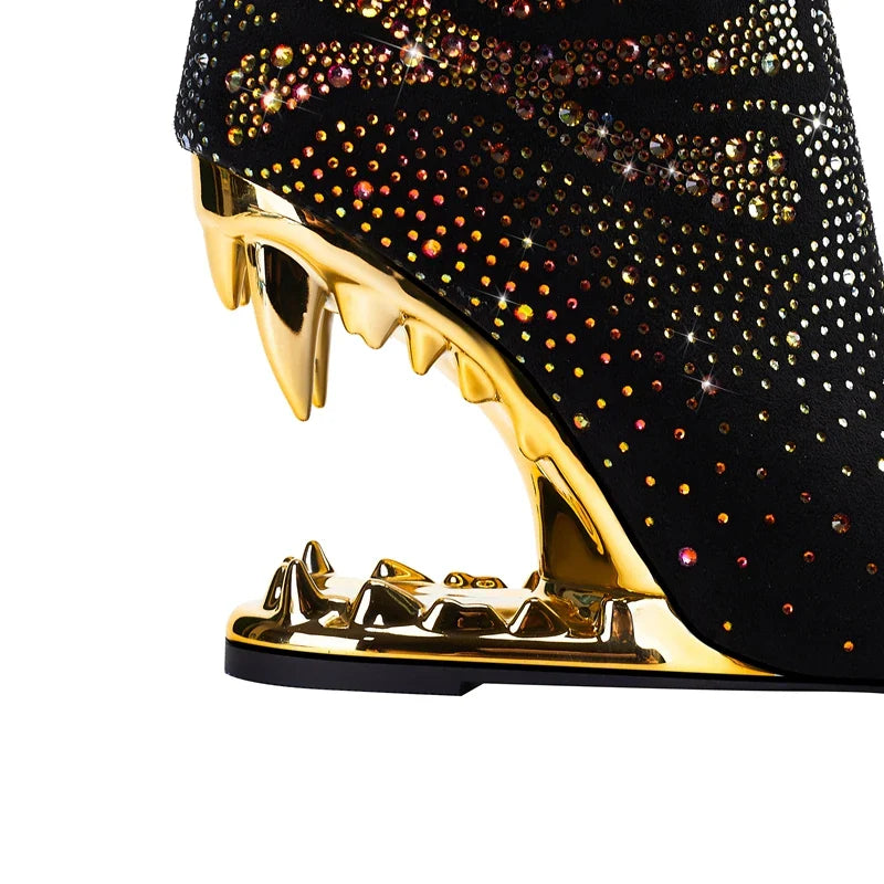 Black high-heeled shoe with gold stiletto heel and rhinestone embellishments on a white background