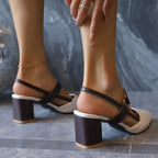 Close-up of feet wearing brown and white sandals with a neutral background
