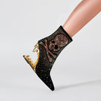 Black sock with gold embellishments worn by a person on a light gray background