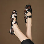 Pair of feet wearing patterned shoes on a brown background