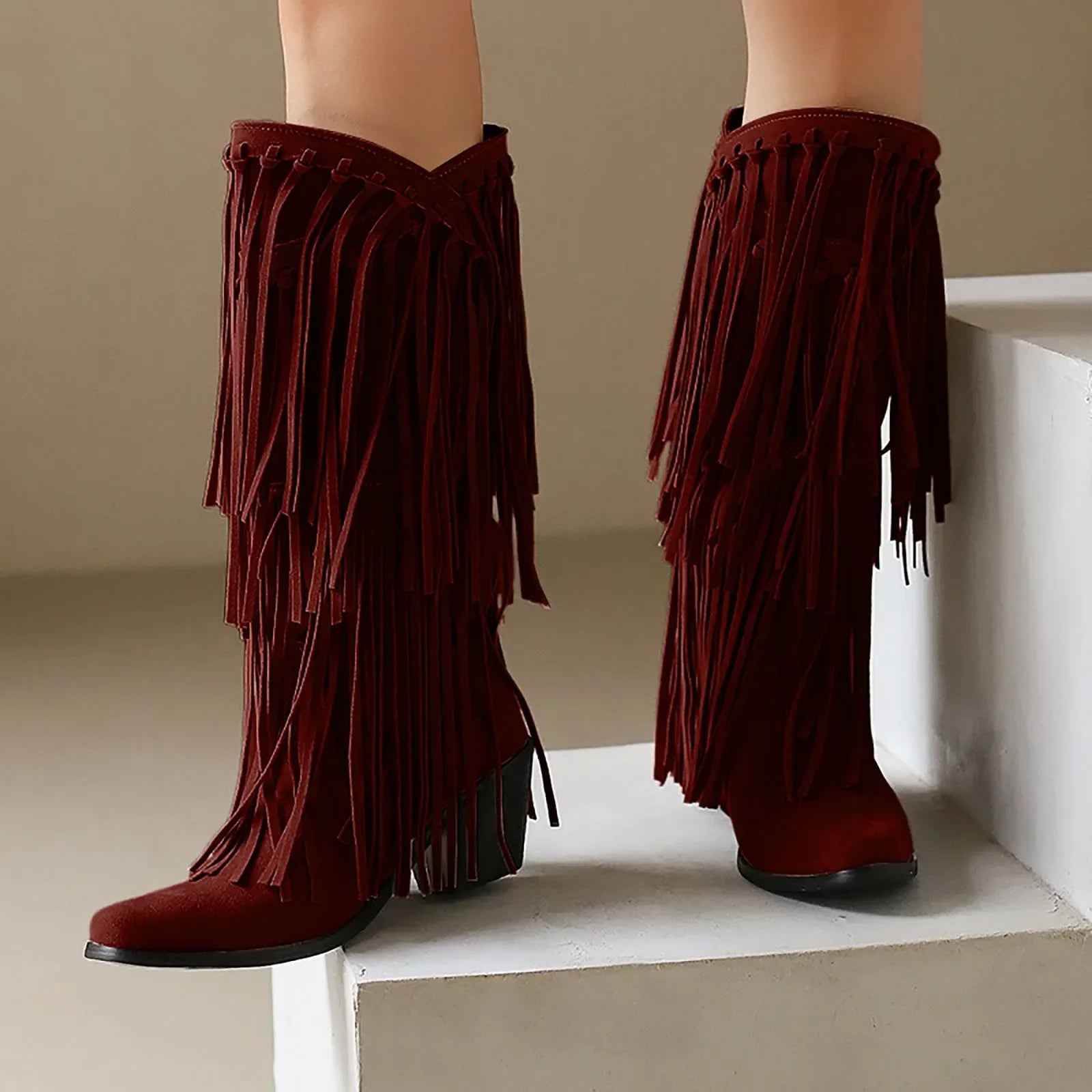 Red fringed boots on a neutral background