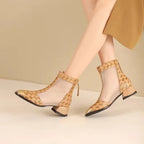 Beige open-toe shoes with floral pattern worn by a person on a beige background